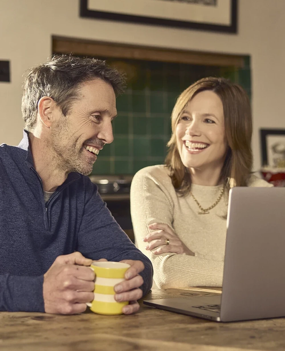 Couple using a laptop together at home in Bedfordshire