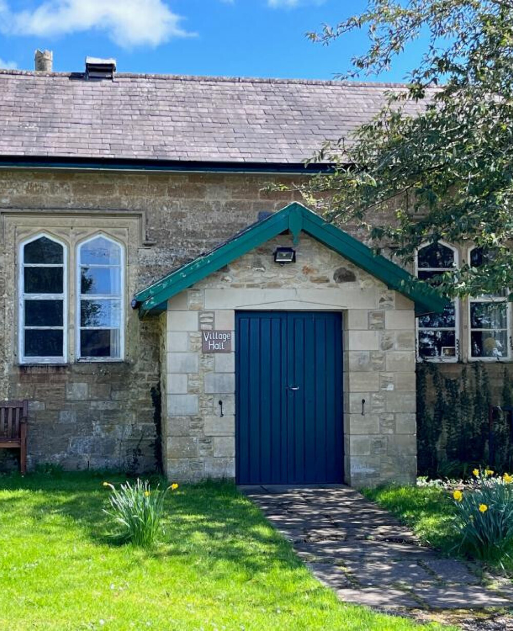 Stone entrance and blue doors of Great Elm Village Hall in Somerset