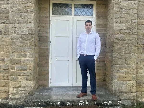 Local representative standing outside Hackforth Village Hall near Bedale, highlighting community connections and broadband services across Bedale, Masham, Morton-on-Swale and surrounding villages.