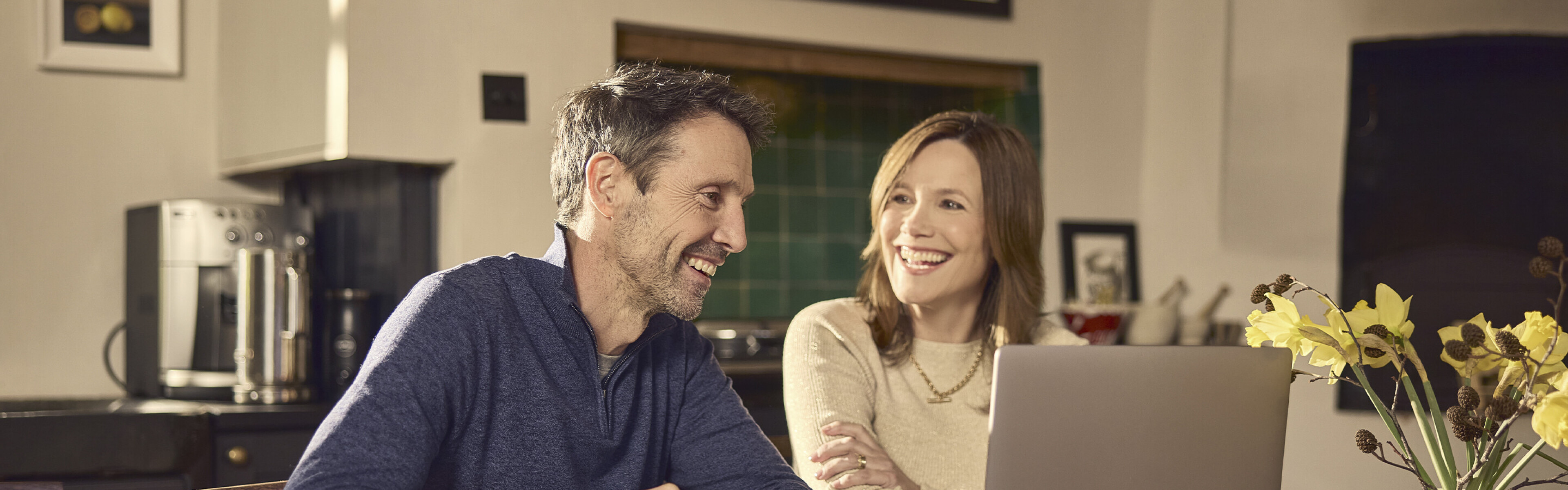 happy couple smiling streaming internet on laptop