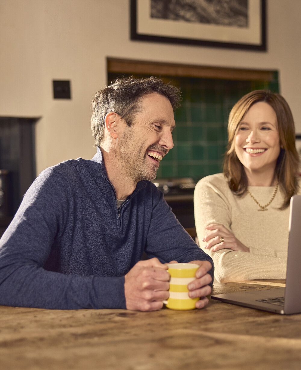 Happy couple smiling at the laptop with streaming video call