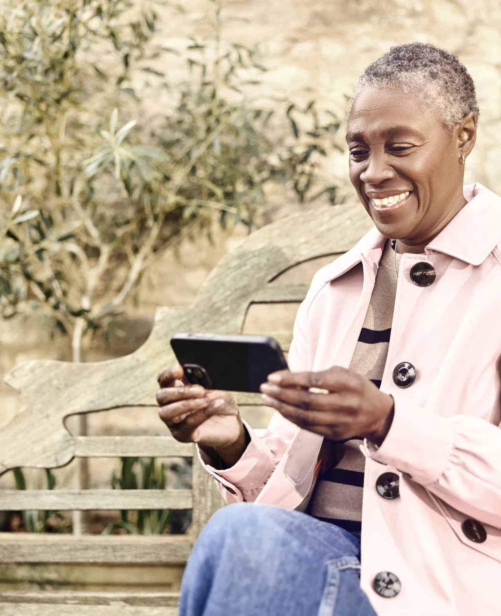 Woman using a smartphone outdoors with Voneus broadband