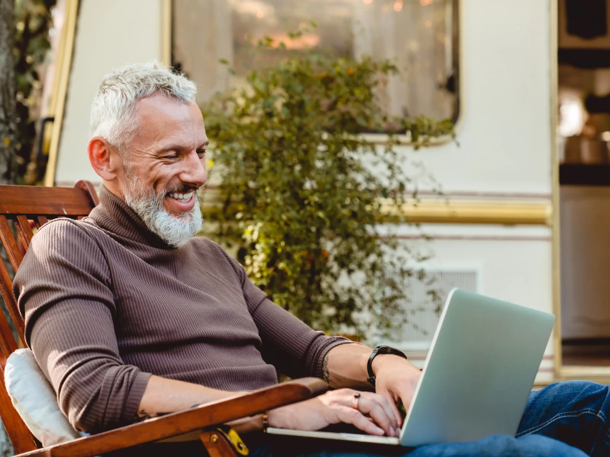 Holiday park guest using Voneus broadband outside a caravan