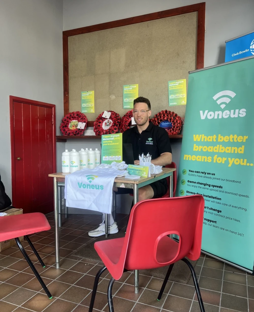 Voneus Broadband representative at a community drop-in session with branded promotional materials, helping residents in Builth Wells, Aberedw and surrounding villages explore their broadband options.
