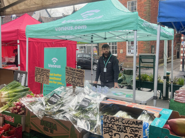 Voneus Broadband representative at a local market stall with branded gazebo and promotional materials, helping residents in Ellesmere, Bagley and surrounding villages explore broadband options.